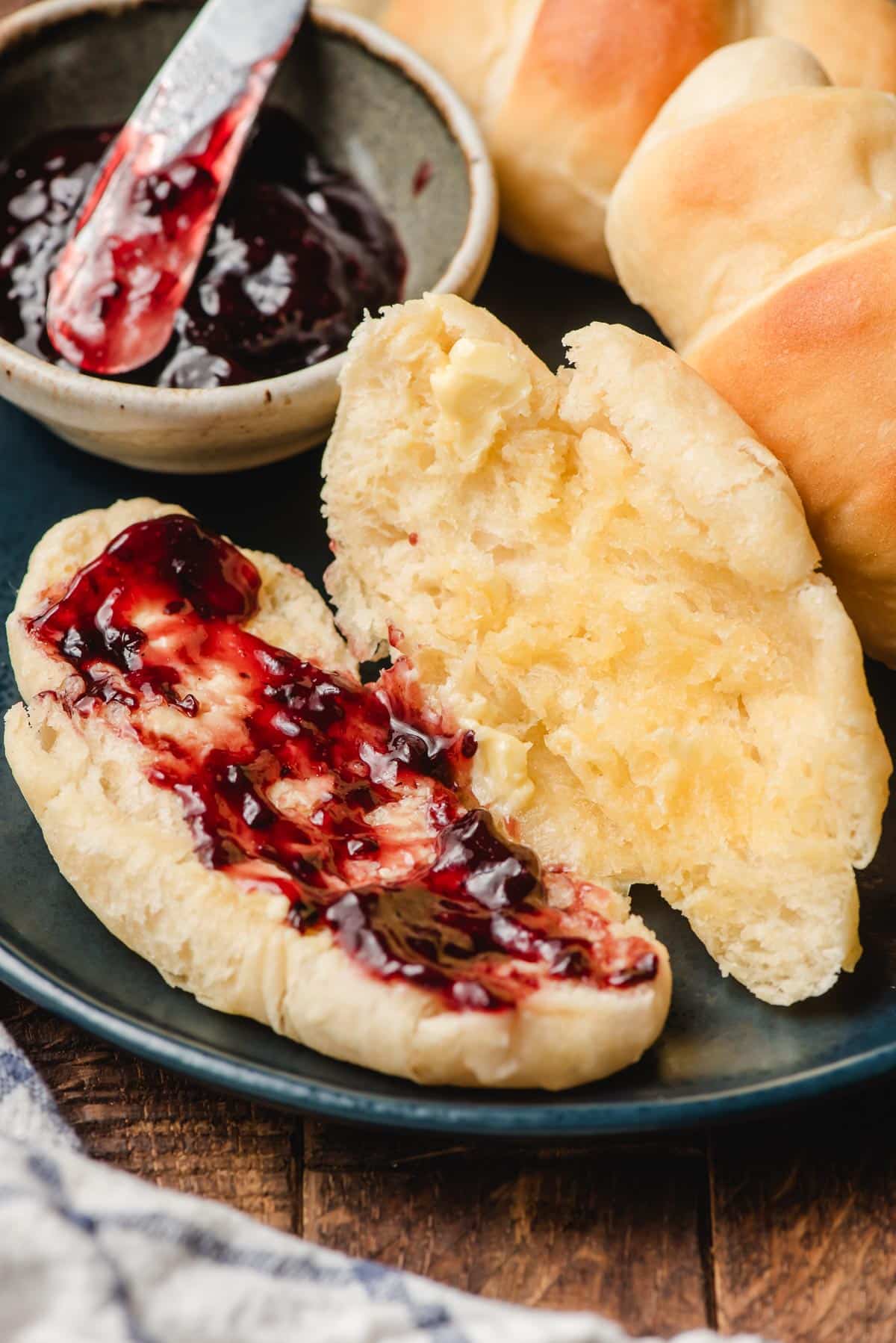 Jam and dinner rolls on a plate.