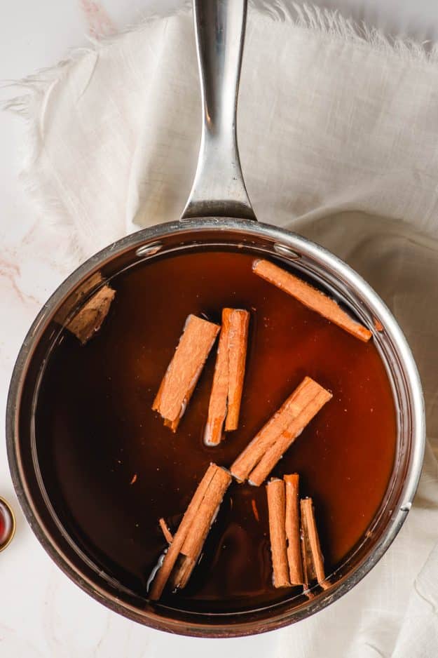 Cinnamon sticks, brown sugar, and water in a saucepan.