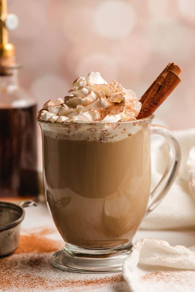 Homemade Cinnamon Dolce Latte in a glass mug, topped with whipped cream and cinnamon sticks.