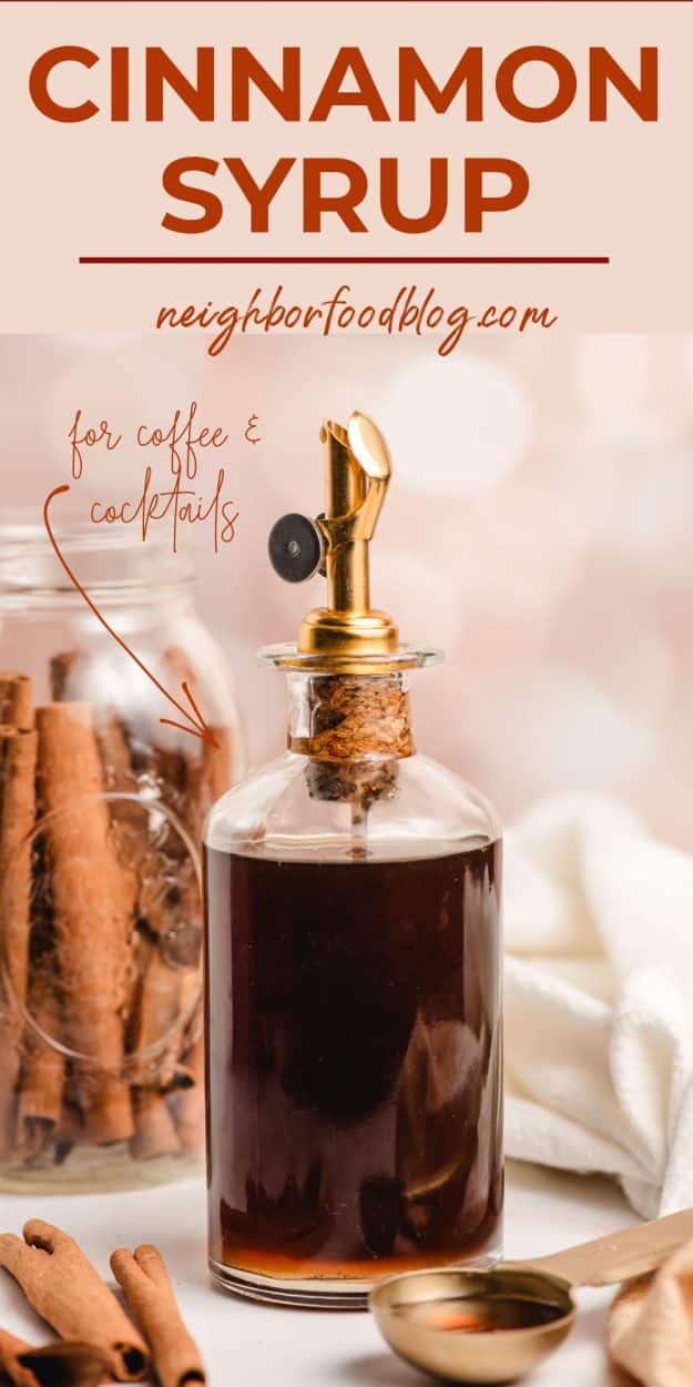 Cinnamon syrup in a glass bottle surrounded by cinnamon sticks.