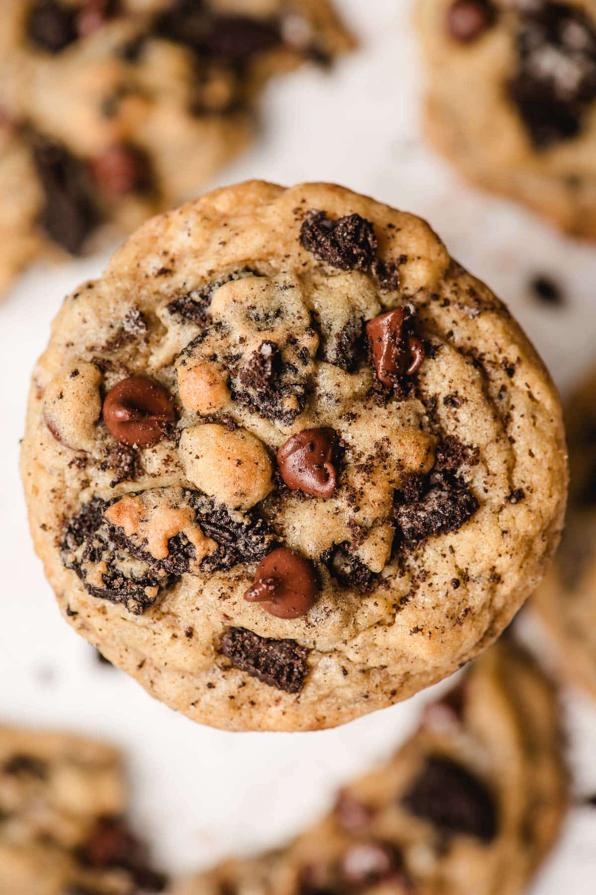 Thick and chewy cookies and cream cookie balancing on top of a glass of milk.