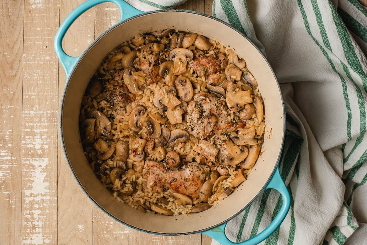 Cooked mushrooms, chicken, and rice in a Dutch oven.