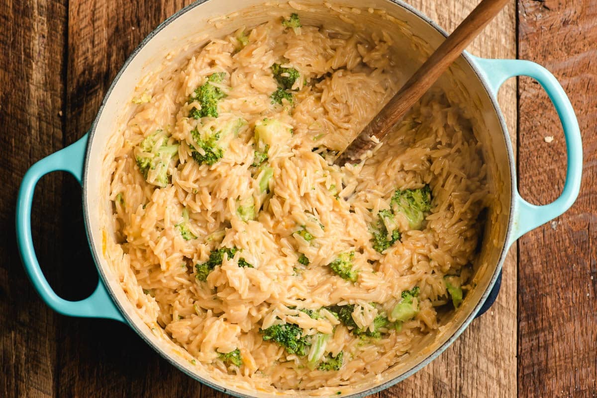 Creamy broccoli orzo with cheese in a Dutch oven.