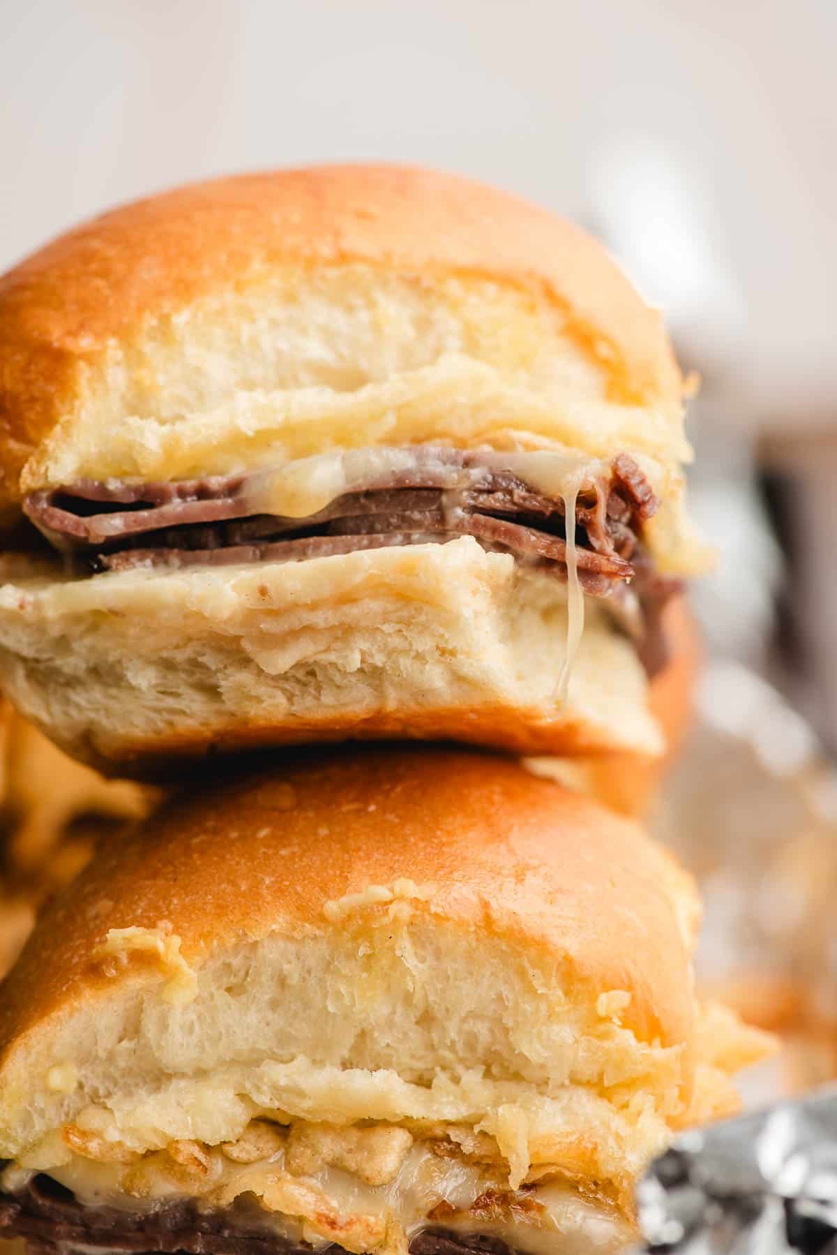 Slider with roast beef, melty white cheddar, horseradish sauce, and french fried onions.