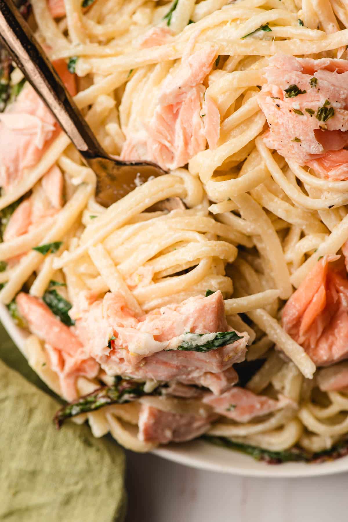 Fork twirling creamy linguine and salmon.