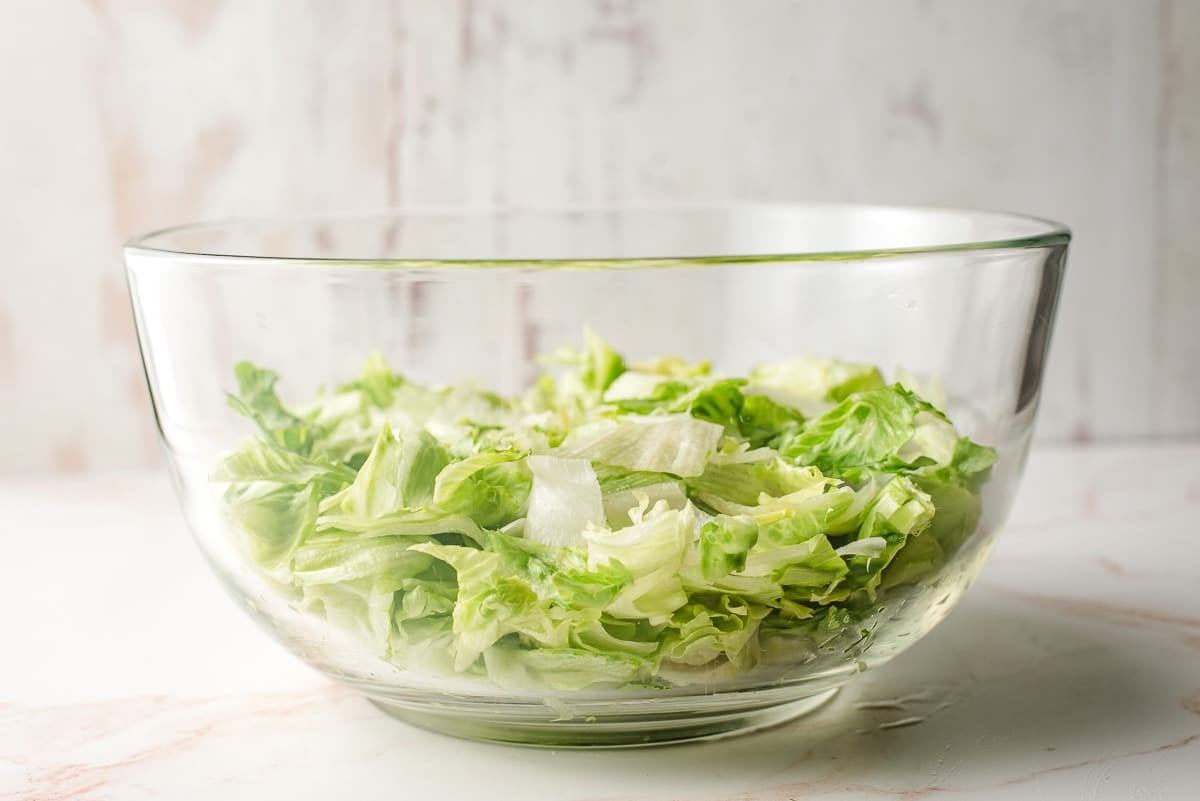 Large glass bowl with iceberg lettuce.