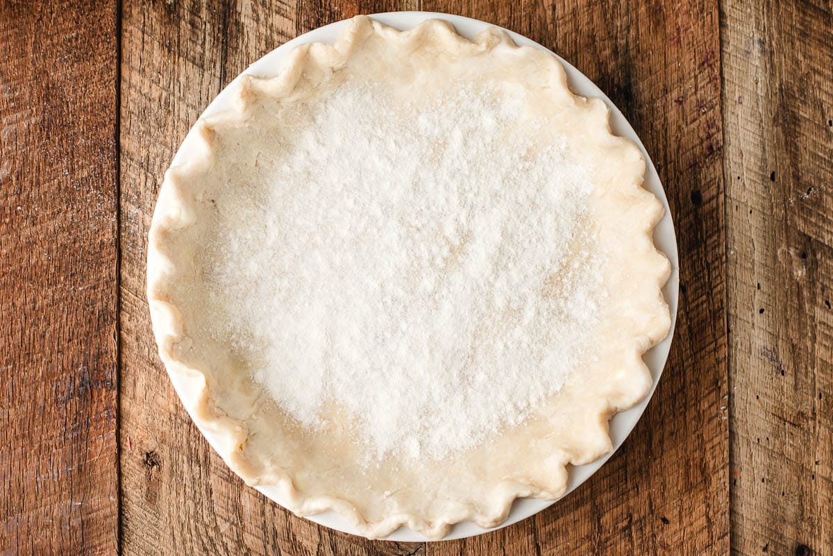 Unbaked pie crust sprinkled with flour and sugar.