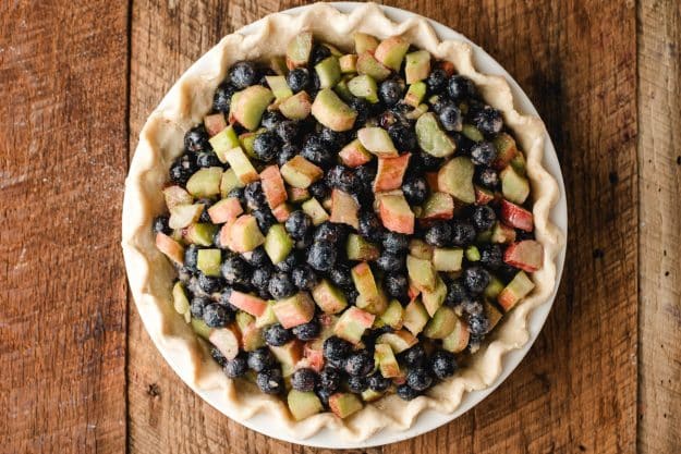 Blueberries and rhubarb in an unbaked pie crust.
