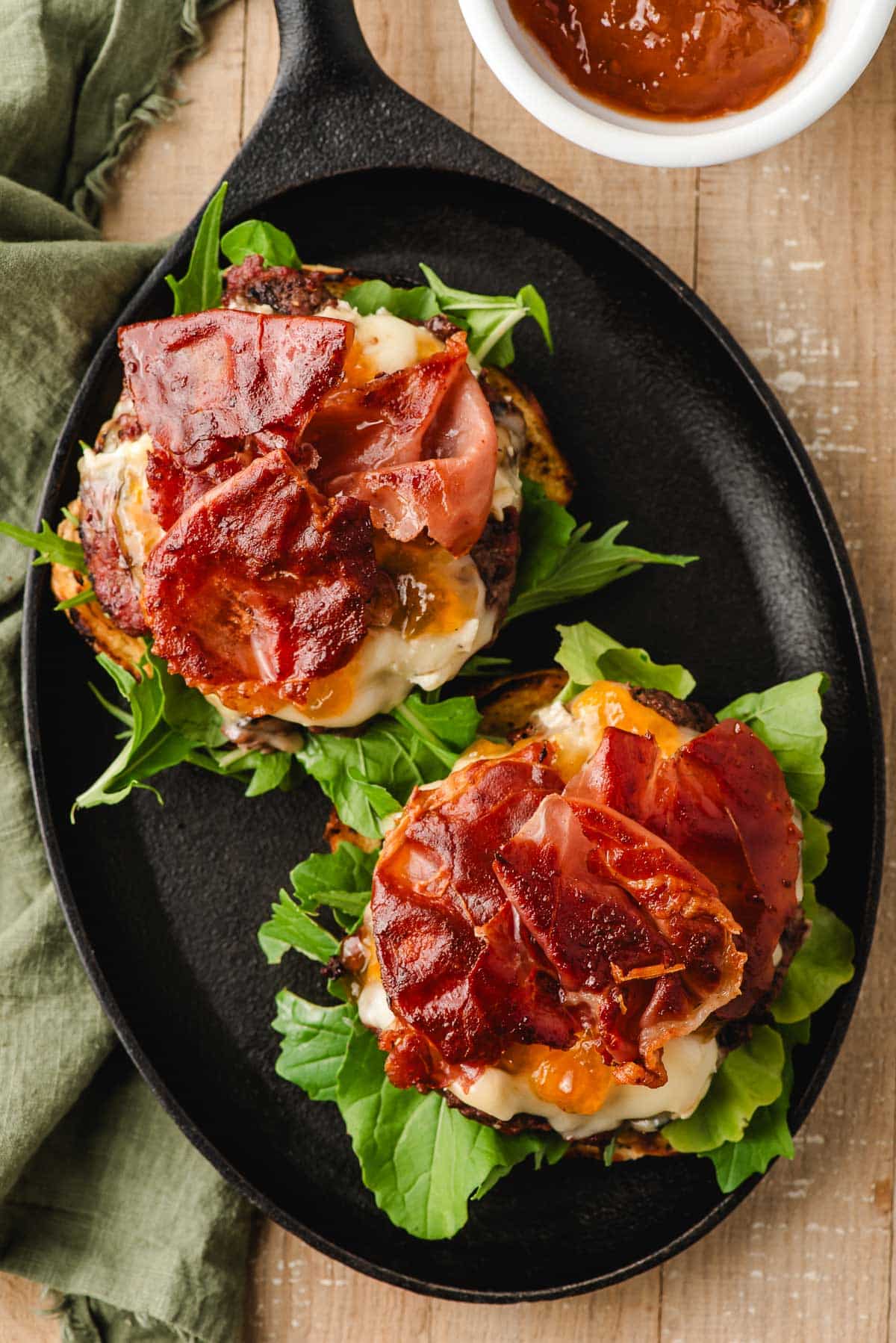 Picture of brie burgers, open faced, with crispy prosciutto on top.