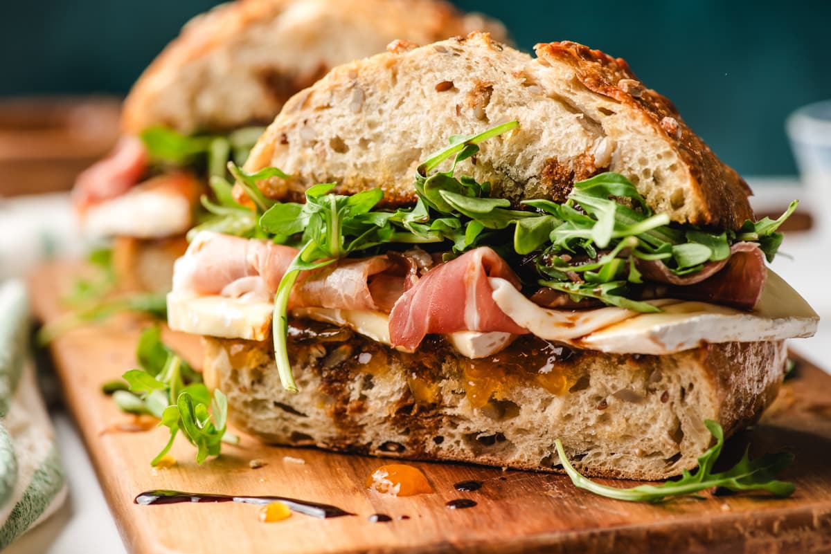 Brie cheese sandwich on a wooden cutting board.