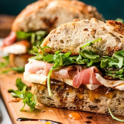 Brie sandwich with prosciutto and balsamic drizzle.