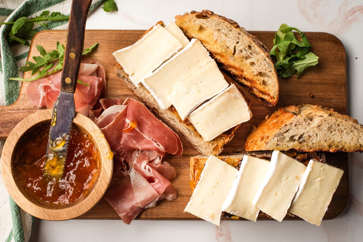 Brie cheese slices layered on top of grilled bread.