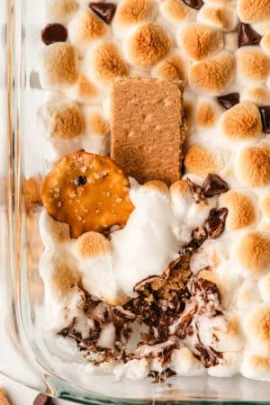 Pretzel crisps and graham crackers dipped in a baked smores casserole.