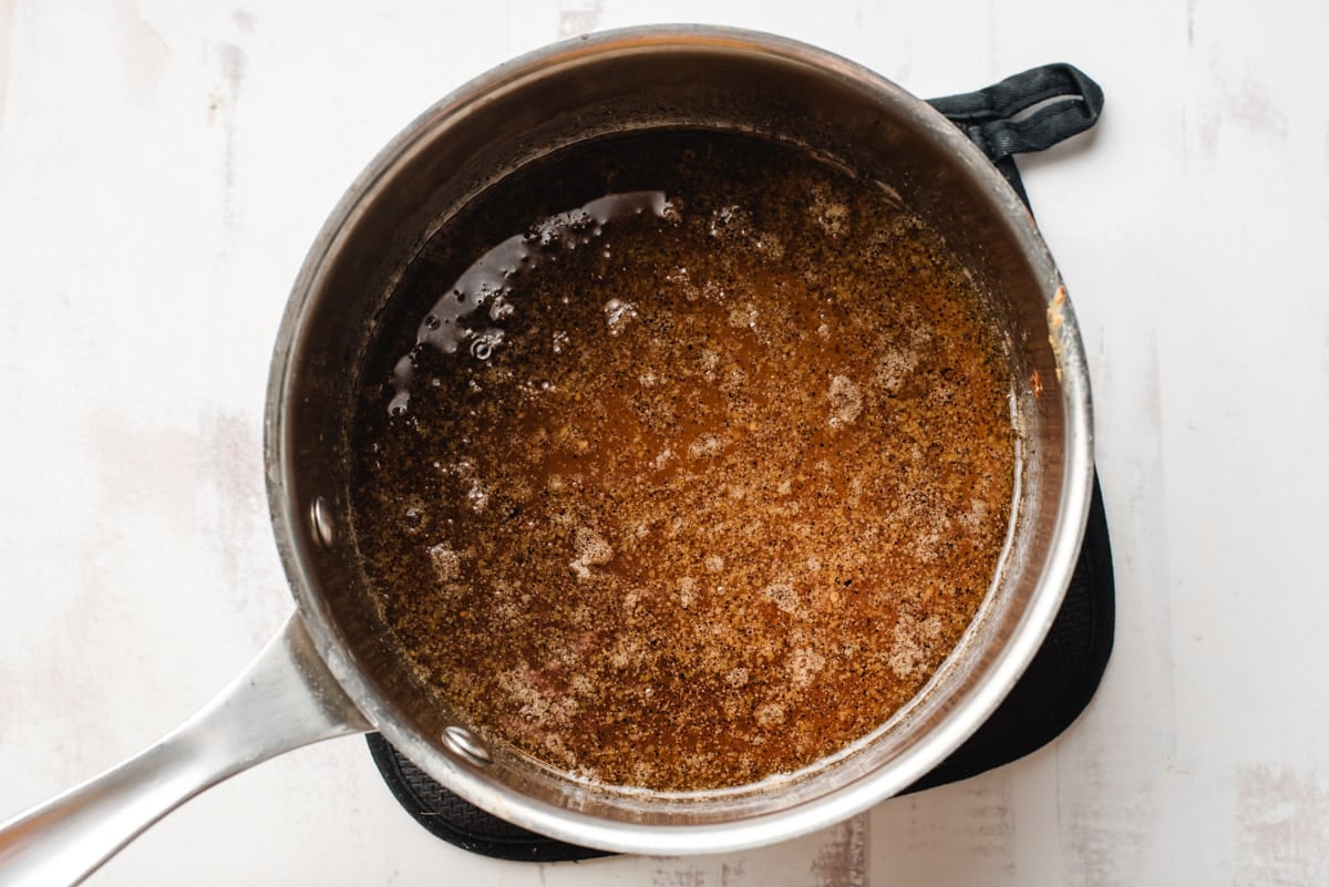 Sweet and sour vinegar marinade for coleslaw in a sauce pot.