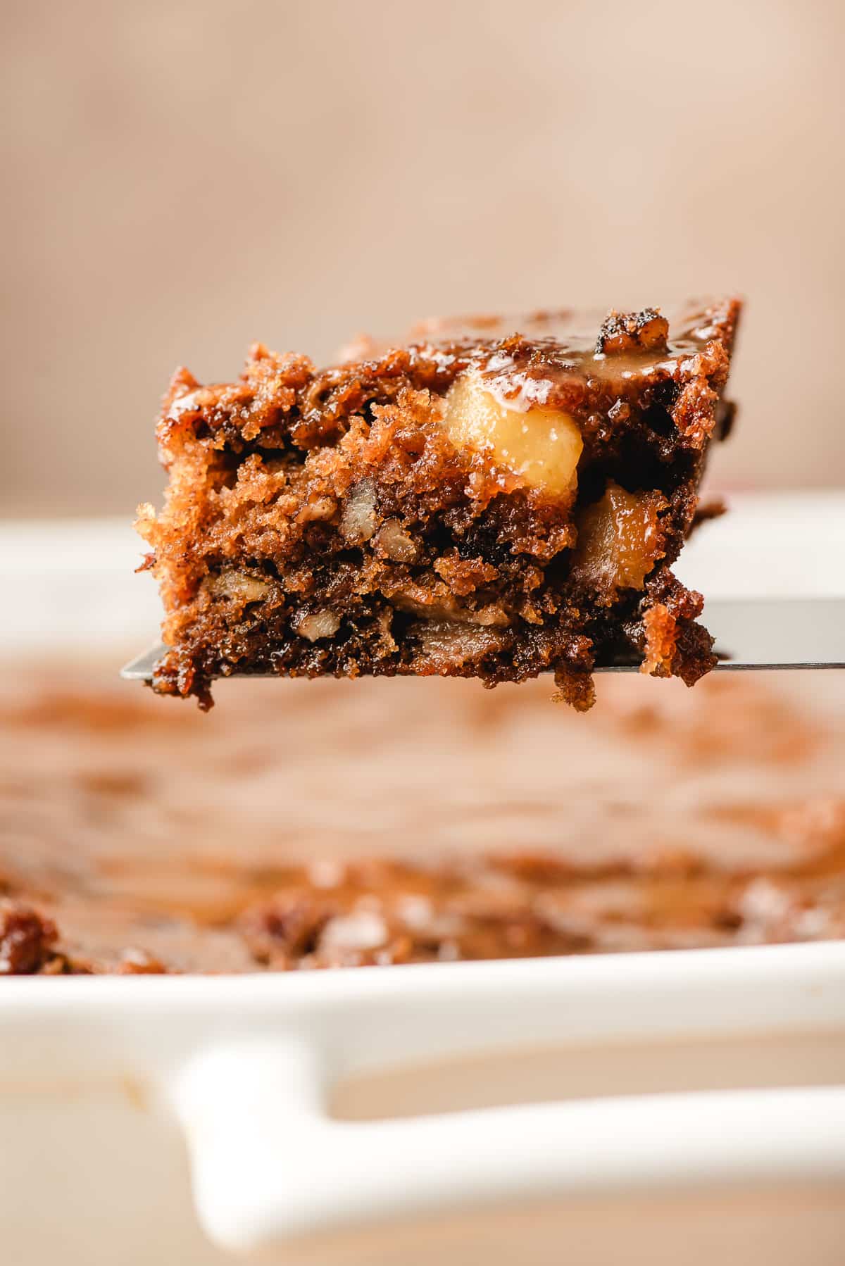 Slice of apple dapple cake on a spatula.