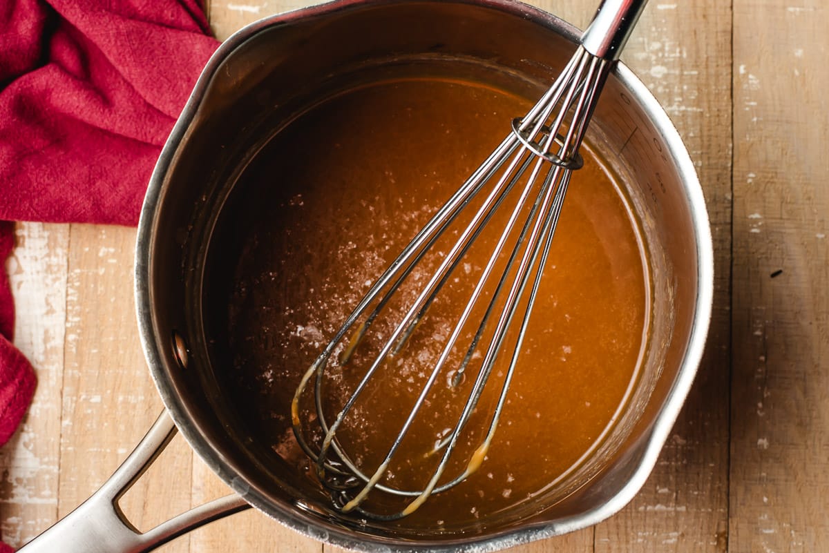 Caramel glaze in a saucepan with salt sprinkled on top.