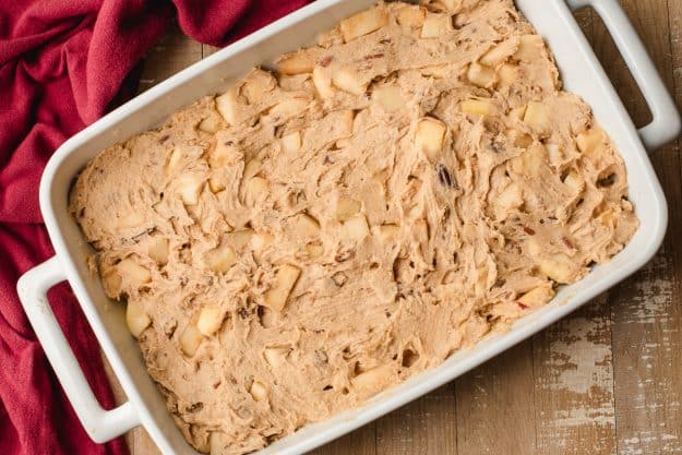 Apple cake spread into a 9 x 13 inch casserole dish.