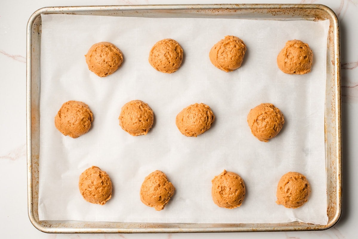 Soft fluffy pumpkin cookie dough scooped onto a baking sheet.