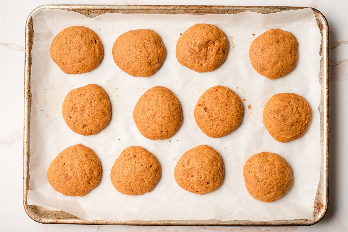 Freshly baked pumpkin cookies on a baking sheet.