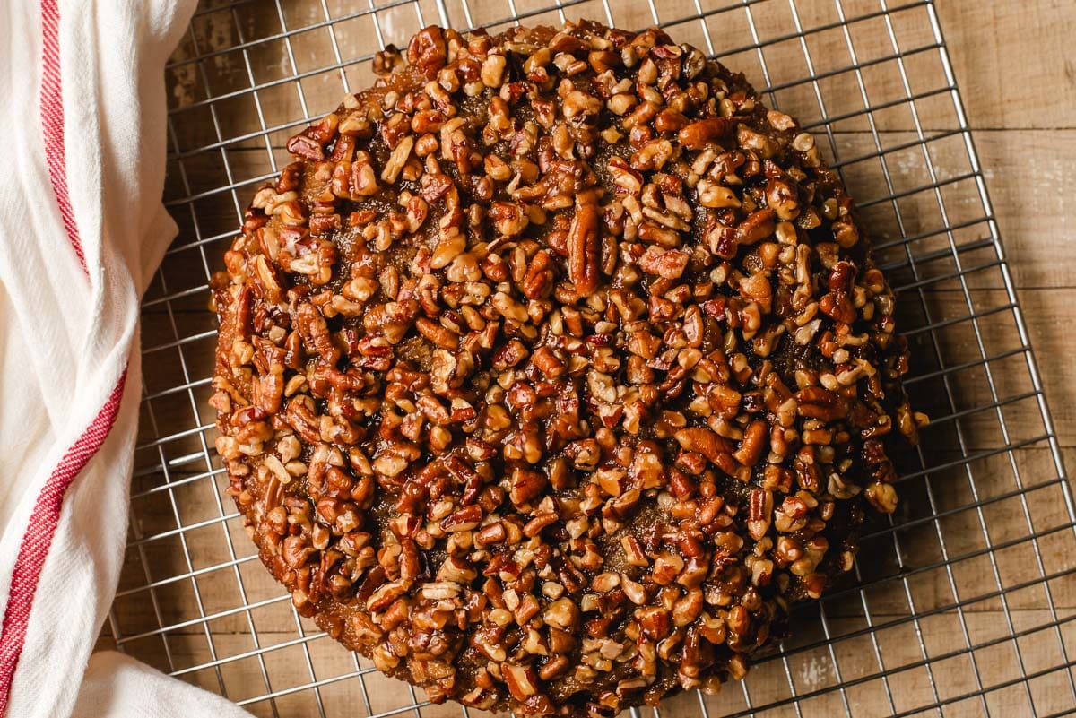 A pecan upside down cake on a cooling rack.