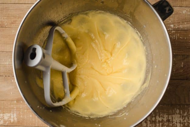 Butter, sugar, and eggs beaten together in a metal bowl.