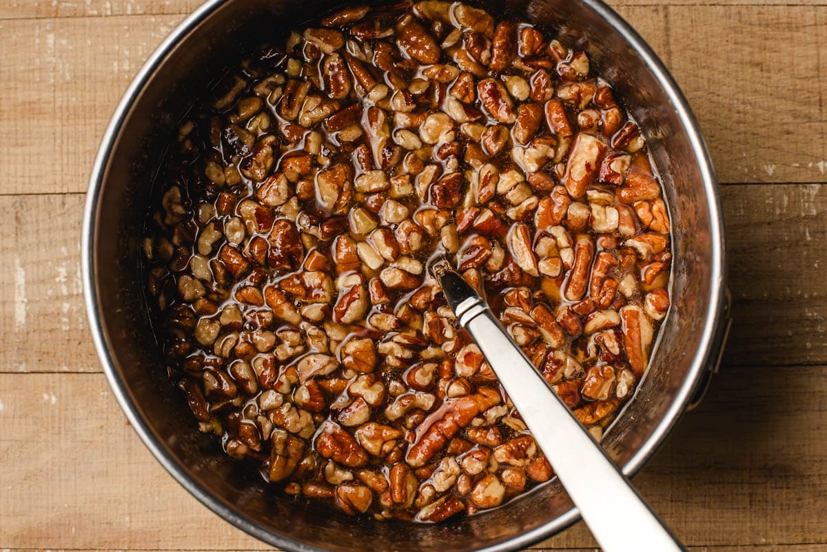 Brown sugar, butter, maple syrup, and pecans mixed together in a small bowl.