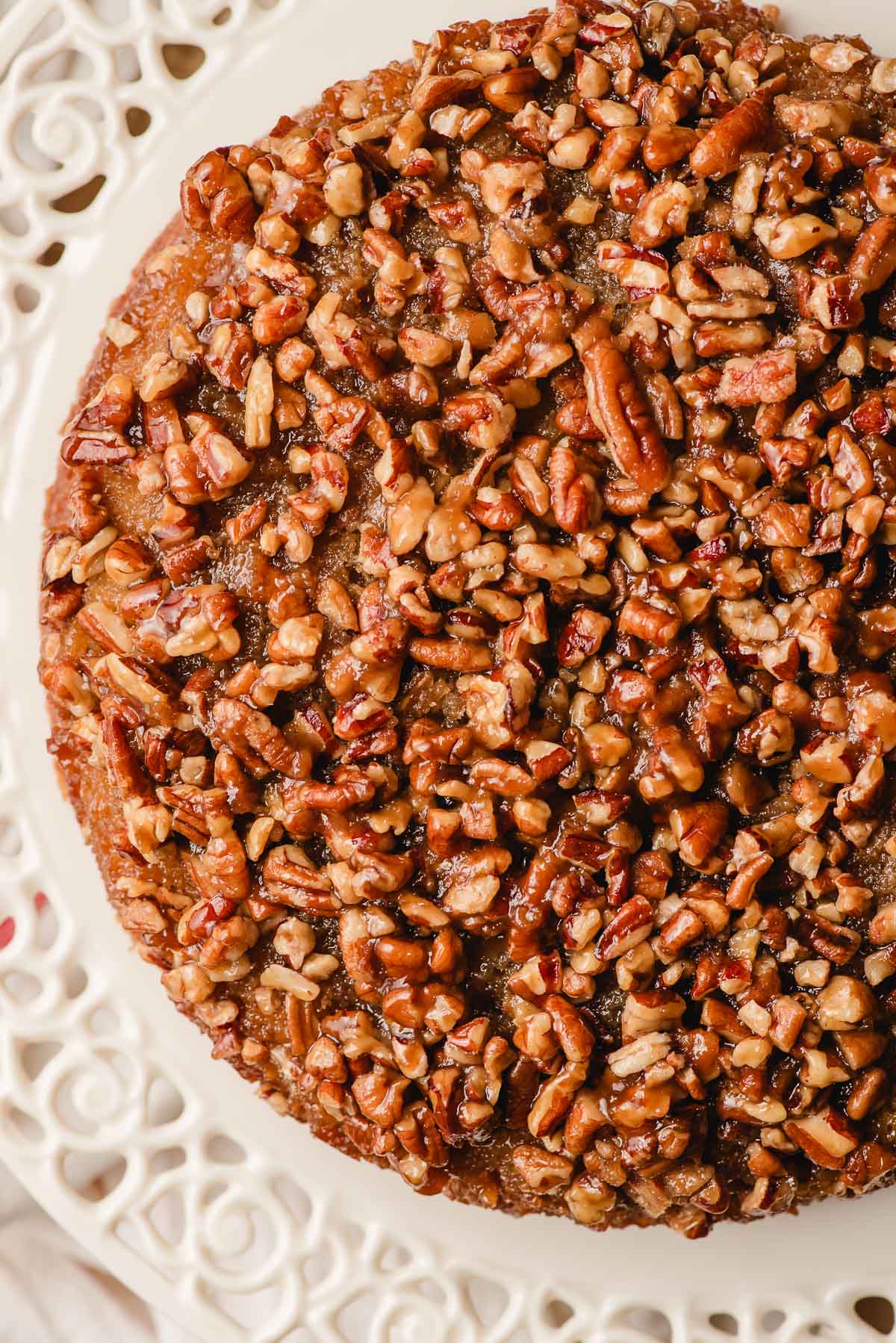 Caramel Pecan Upside Down Cake on a lacy edged cake platter.