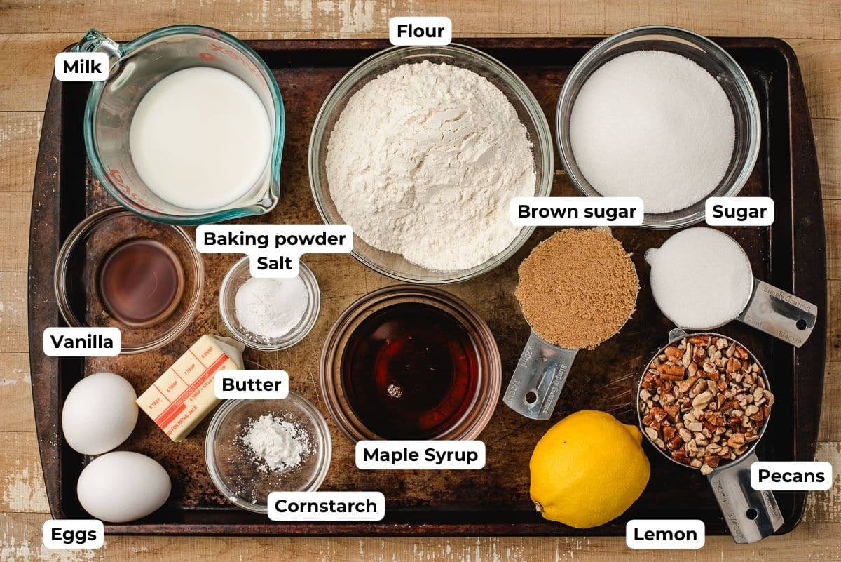 Bowls of milk, flour, sugar, brown sugar, pecans, lemons, maple syrup, baking soda and salt, eggs, and butter.
