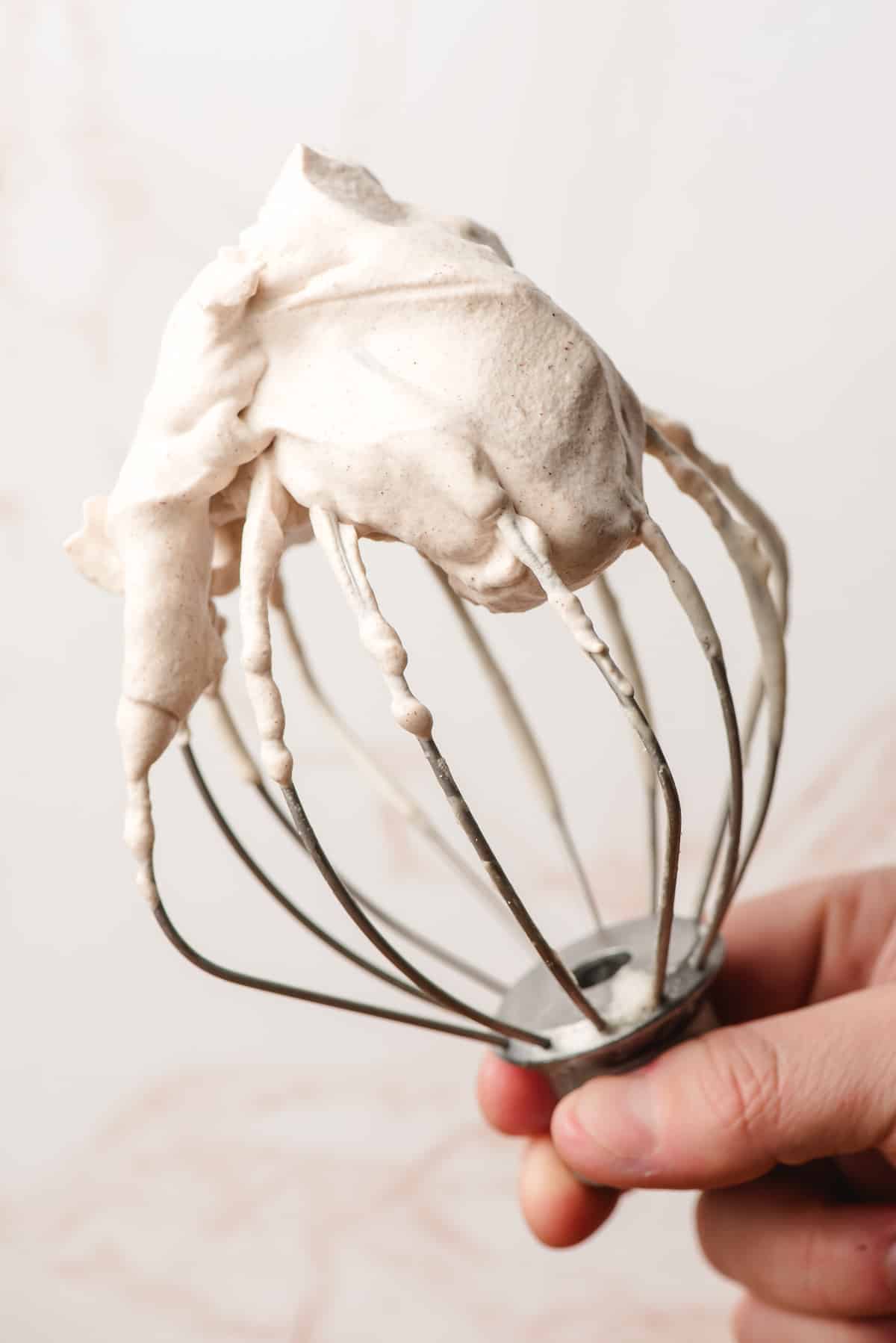 Whisk attachment covered in cinnamon whipped cream.