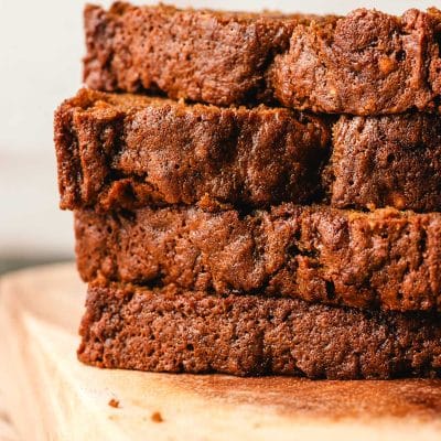 a stack of 4 slices of banana gingerbread loaf on a cutting board