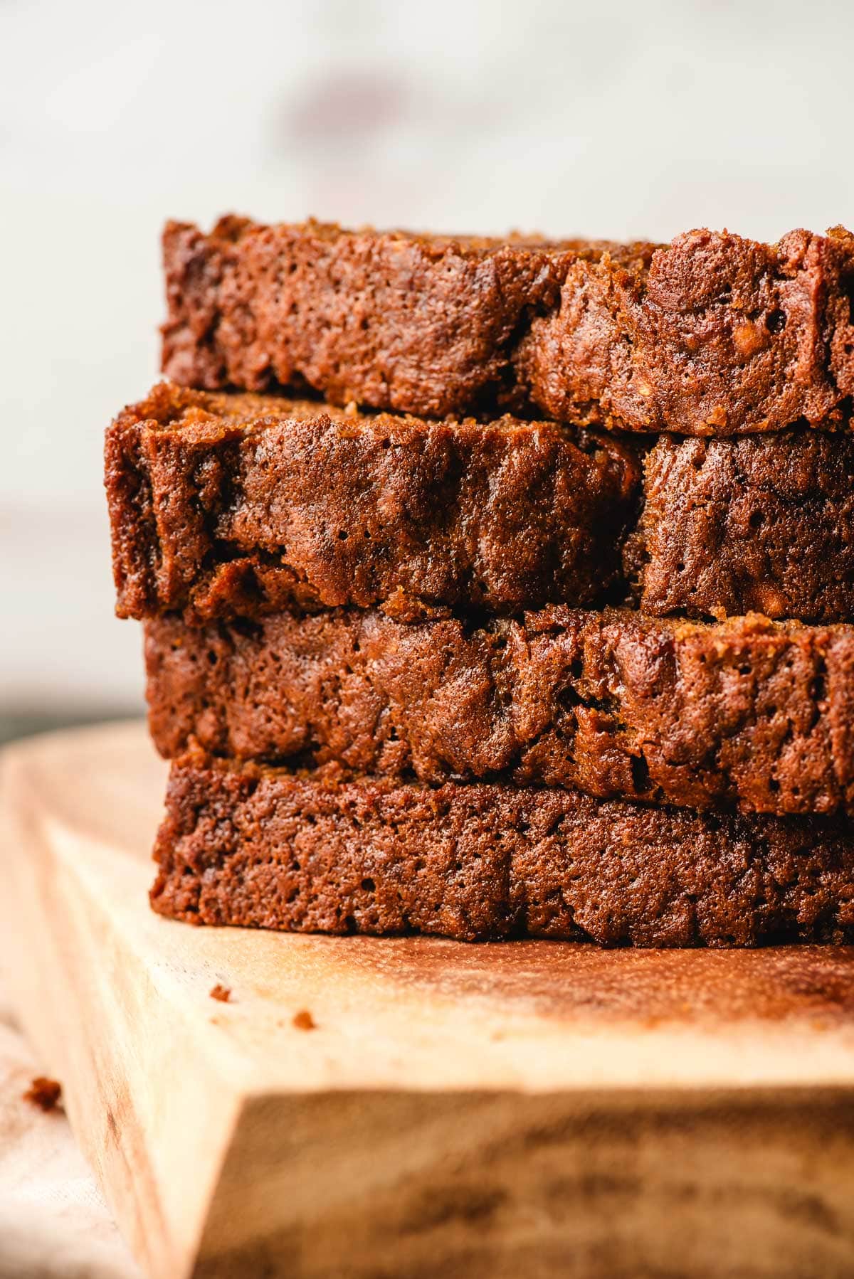 a stack of 4 slices of banana gingerbread loaf on a cutting board