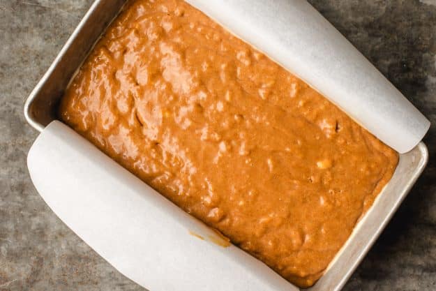 a parchment-lined baking pan filled with bread batter