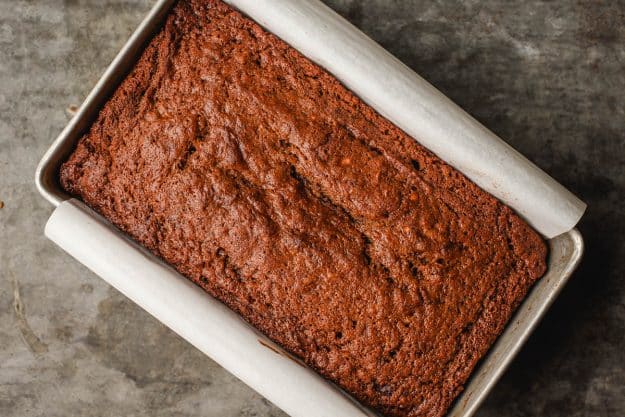 the baked loaf of banana gingerbread cooling in the pan