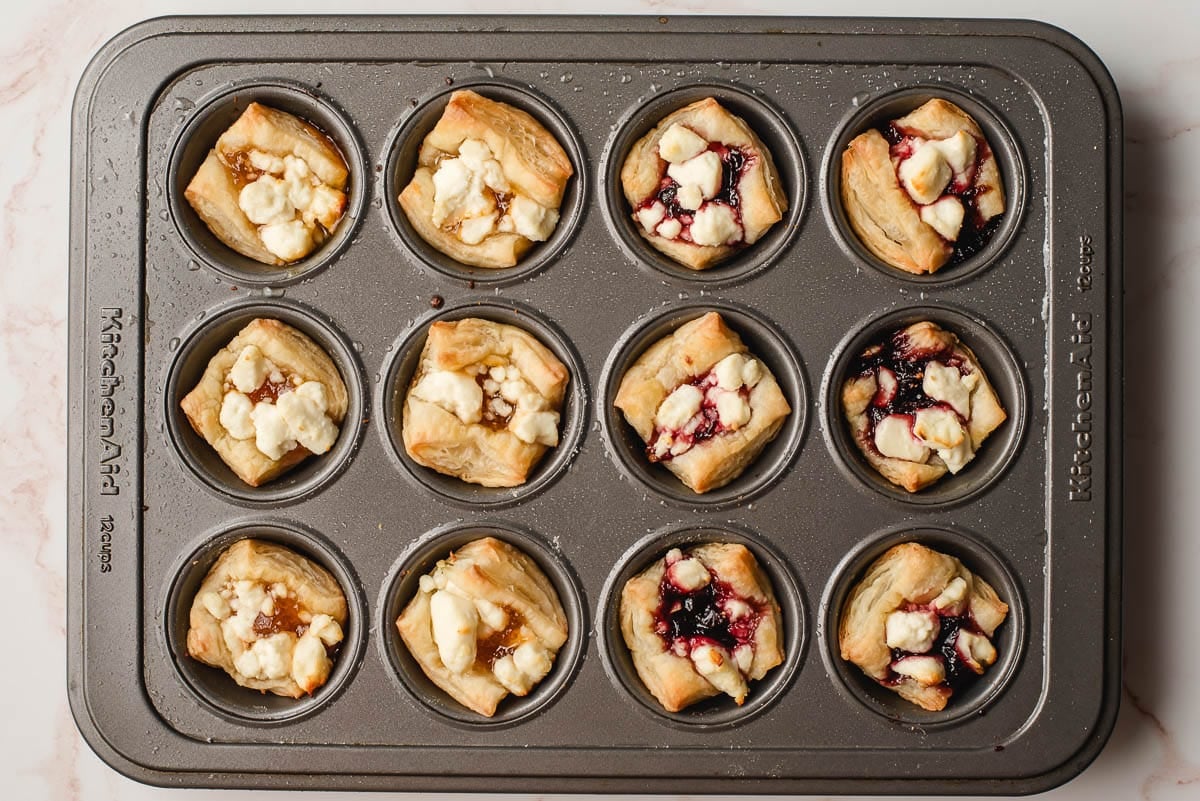 Puff pastry with goat cheese and jam in a mini muffin tin.