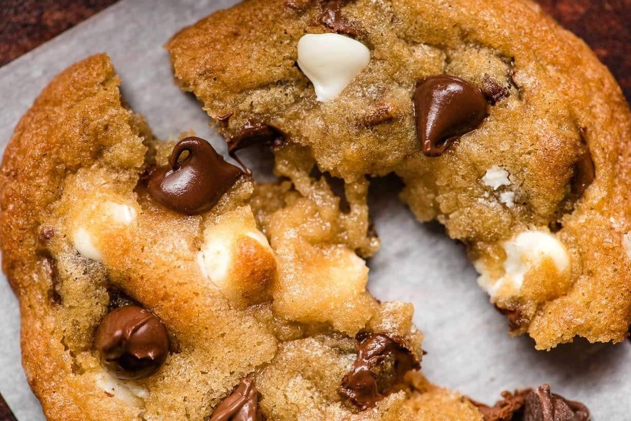 Triple Chip Cookies photo triple chocolate chip cookie being pulled apart to reveal gooey centers