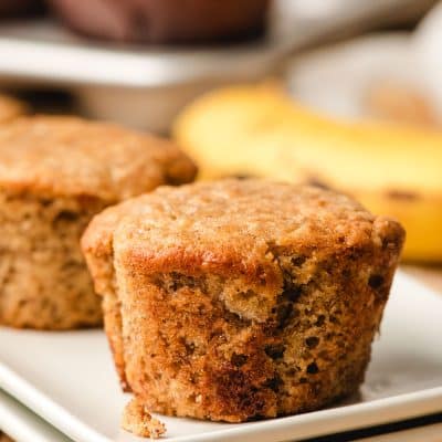 Sour cream banana muffin sitting on a white plate.