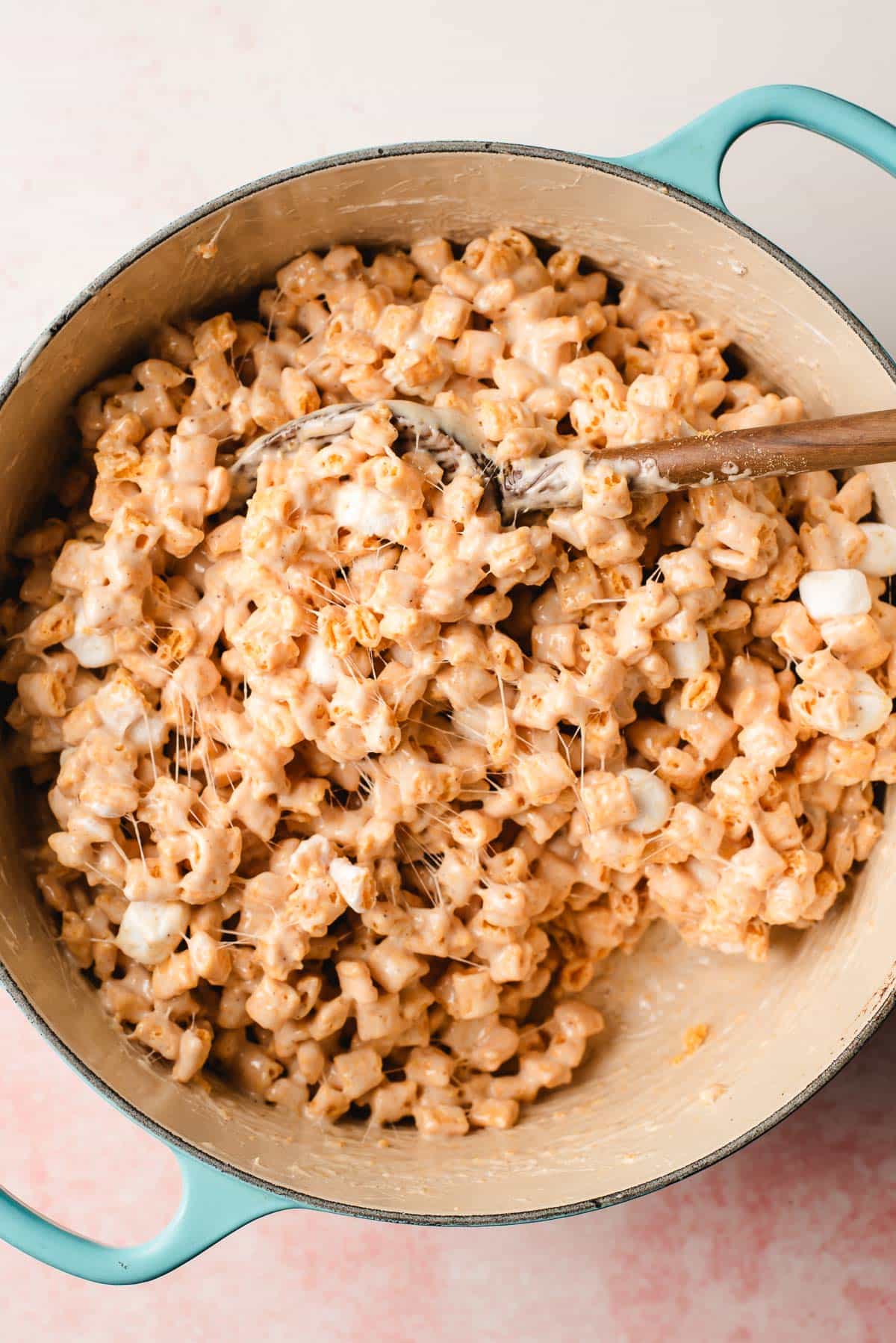 Captain crunch cereal and buttery marshmallows stirred together in a Dutch oven.