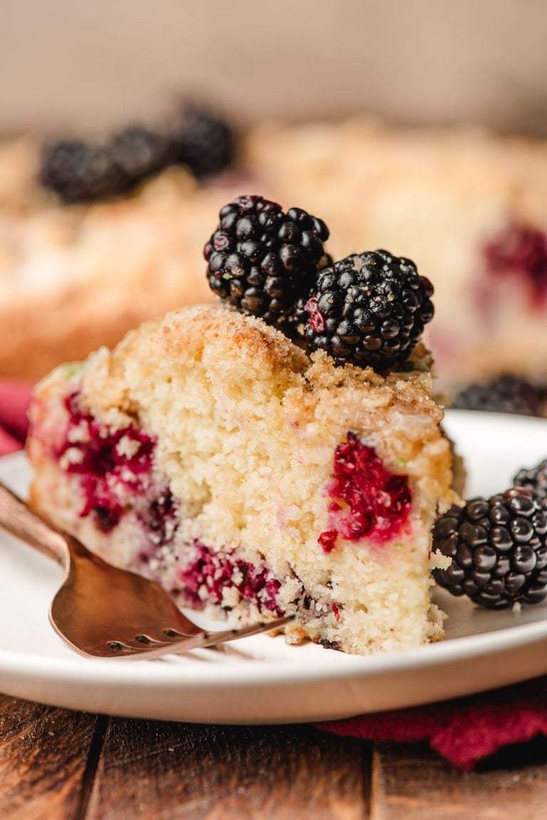 Slice of Blackberry Cake with crumb topping on a white plate.