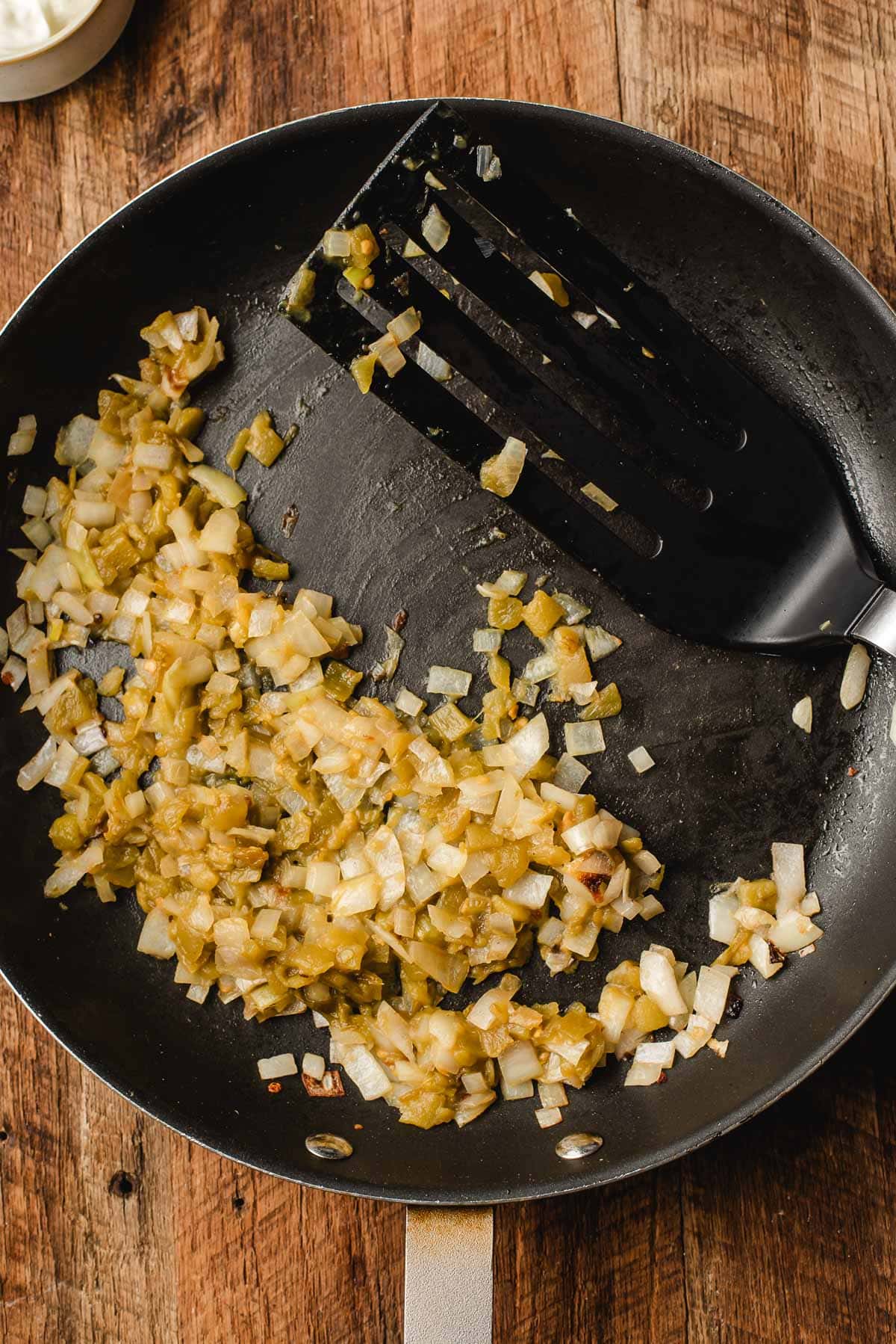 Sautรฉed onions and green chiles cooking in a skillet for quesadilla filling.