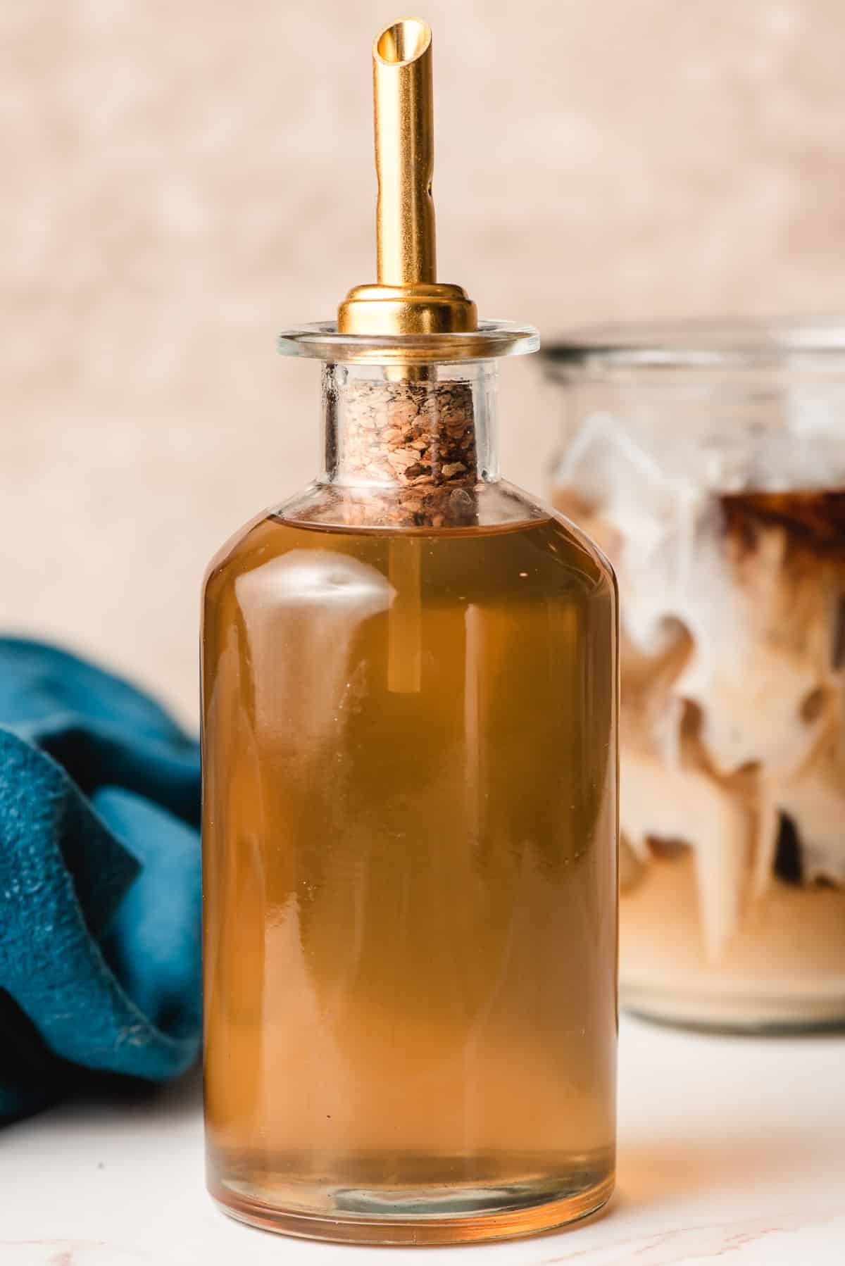Glass bottle filled with cane sugar syrup and topped with a gold bottle stopper.