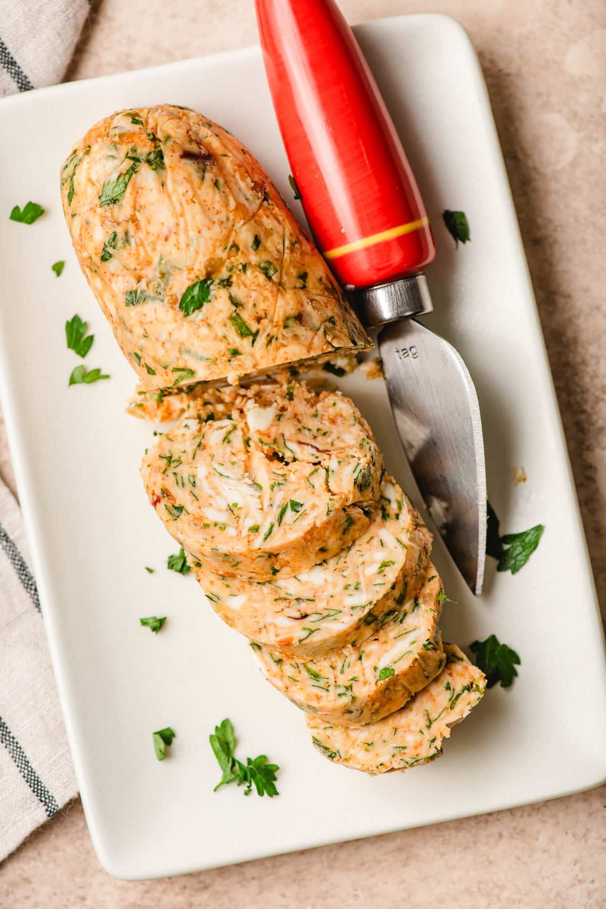 Cowboy butter sliced on a platter with a serving knife.