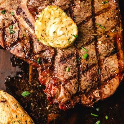 Cowboy butter on top of a grilled T-bone steak.