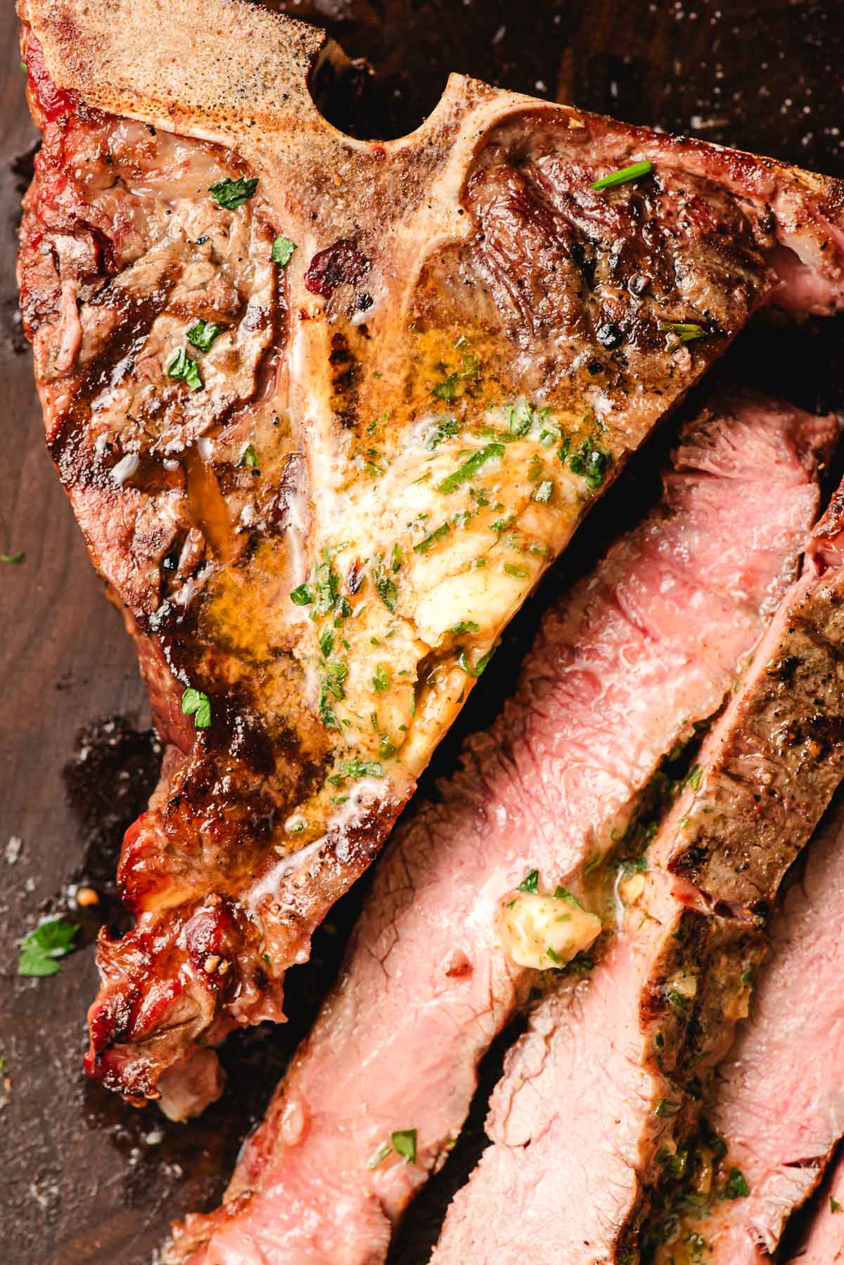 T-bone steak, sliced and topped with compound butter.