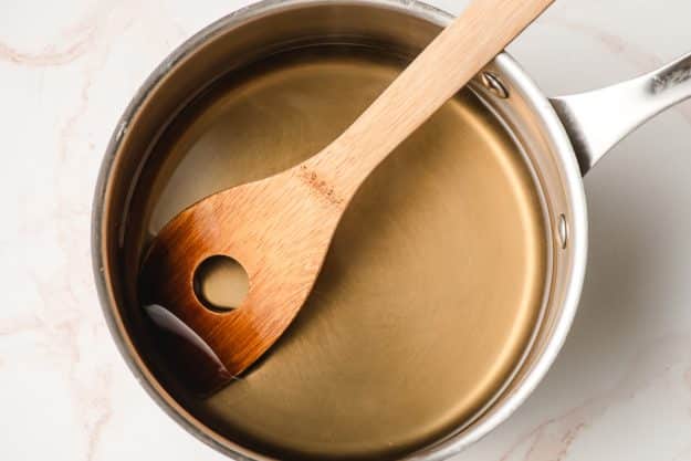 Cane sugar dissolved into water in a sauce pan.