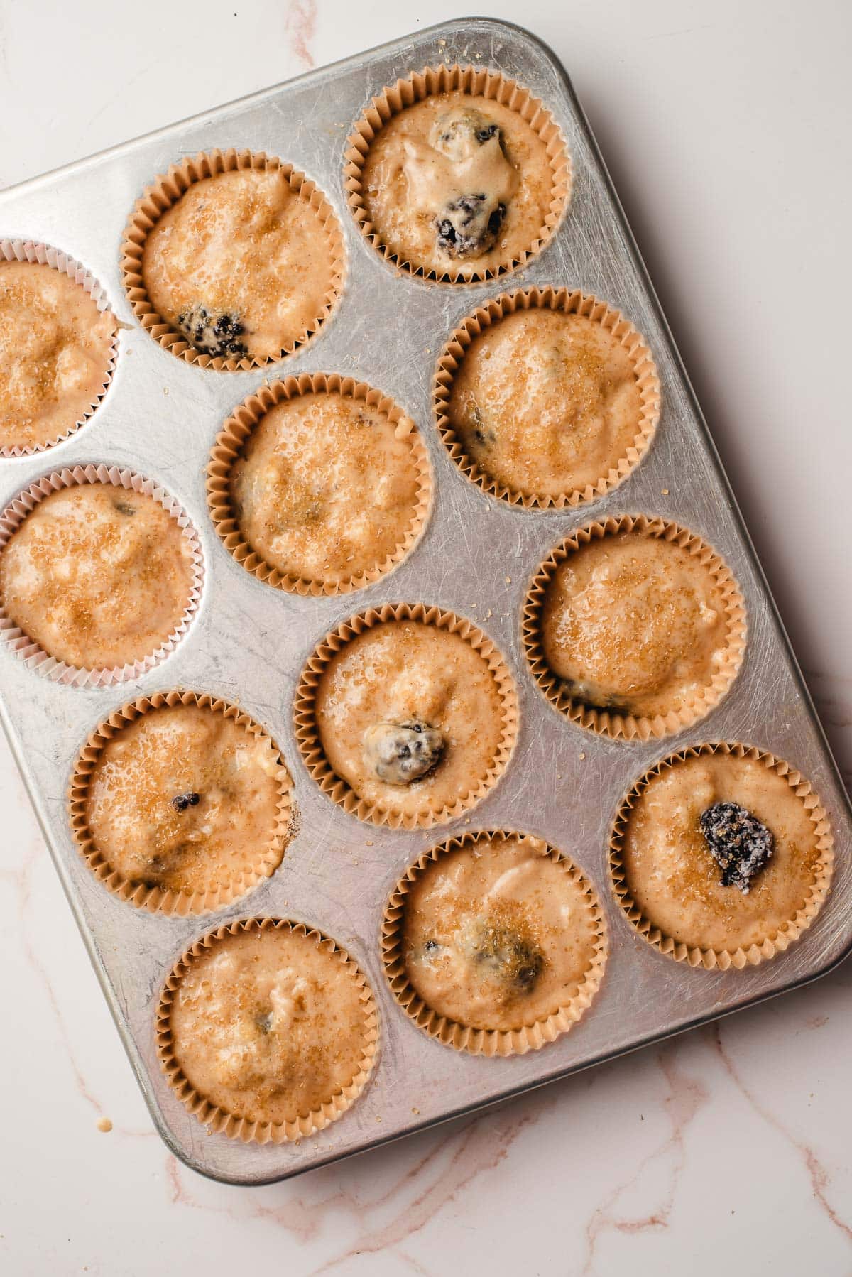 raw batter poured into paper liners in a muffin tin