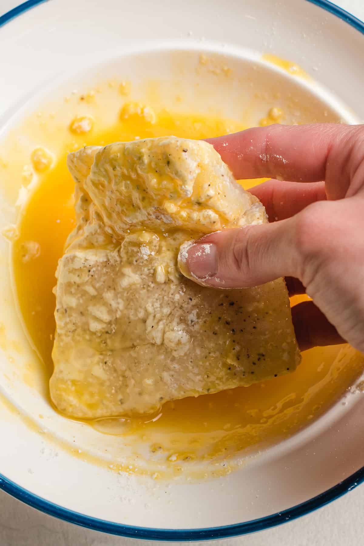 dipping the cod into the egg mixture. 