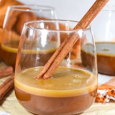 Hot Buttered Brandy in a mug with a cinnamon stick.