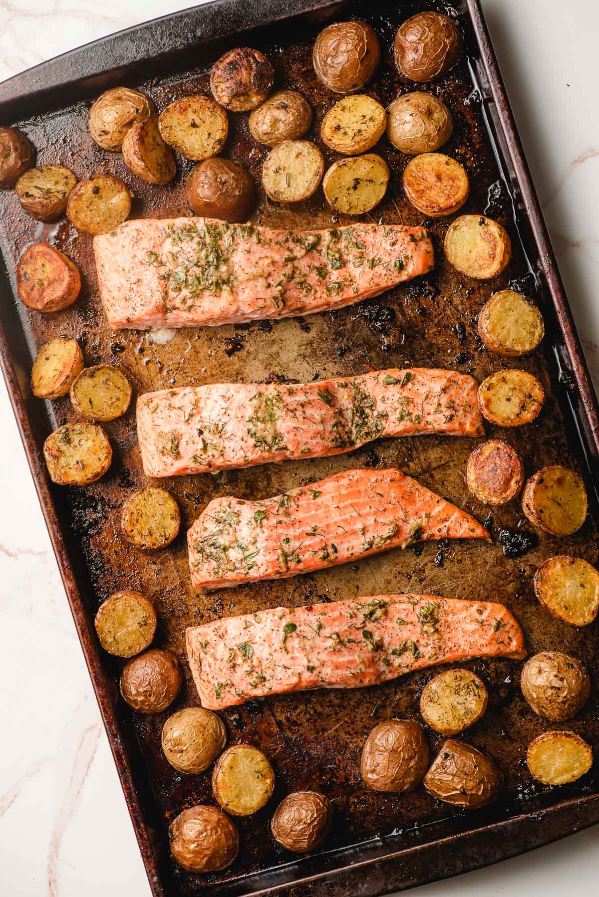 Baked salmon and potatoes on a sheet pan.