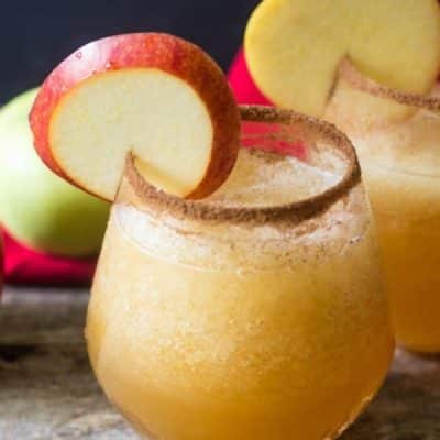 Apple Vodka Slush with a cinnaon rim and garnished with an apple slice.