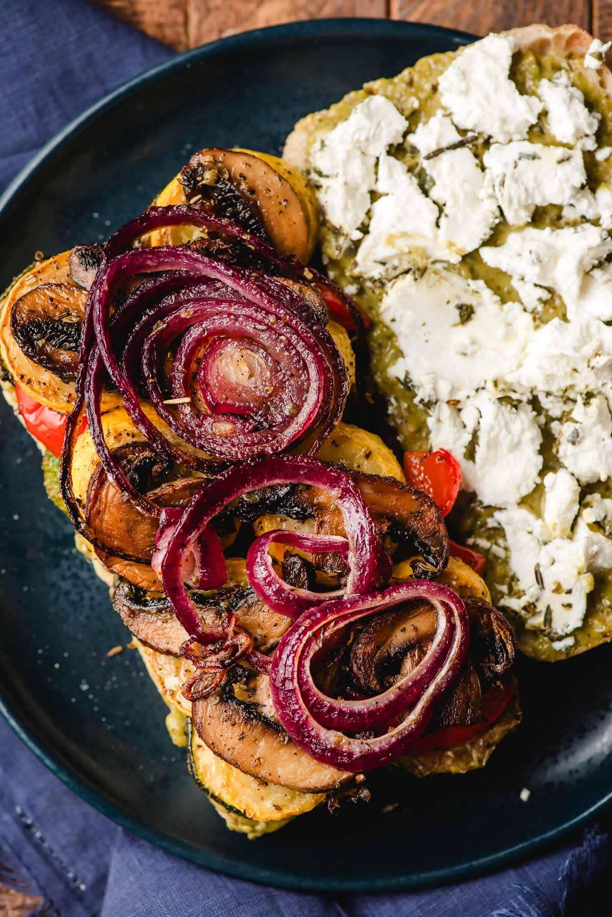 Open faced veggie sandwich with goat cheese and pesto.